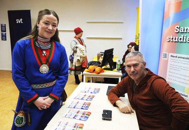 Kvinne med kofte besøker stand