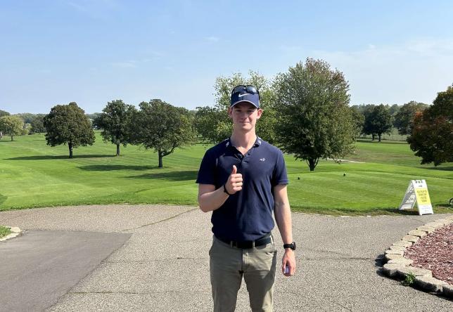 Mann på golfbane gir tommelen opp