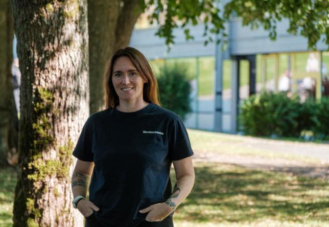 Dame står ved siden av et tre