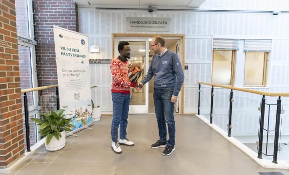 Heder og håndtrykk: Prodekan Terje Andreas Mathisen gratulere stipendiat Samuel Asumadu Sarkodie med nok en gang å være på lista over de mest siterte forskerne i verden. Foto: Svein-Arnt Eriksen.