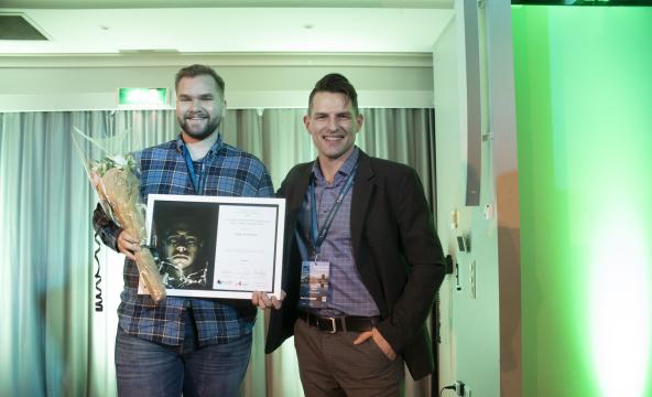 Vinner av High North Young Entreprenur-pris står på scenen med blomst er og diplom sammen med representant fra Innovasjon Norge Nordland