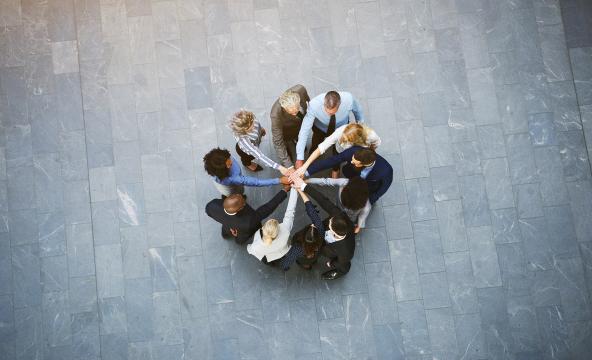 Mennesker står i ring og holder hender