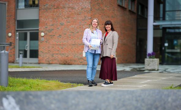 De to forskerne står foran hovedinngangen til Nord universitet.