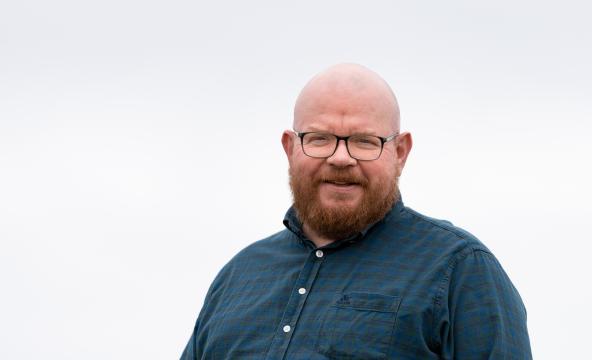 Voksen mann i blå skjorte. Foto