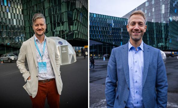 To voksne menn i dressjakke ute foran store bygg. Foto