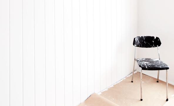 Illustrasjonsbilde av tom stol i et hjørne i et rom som skal males