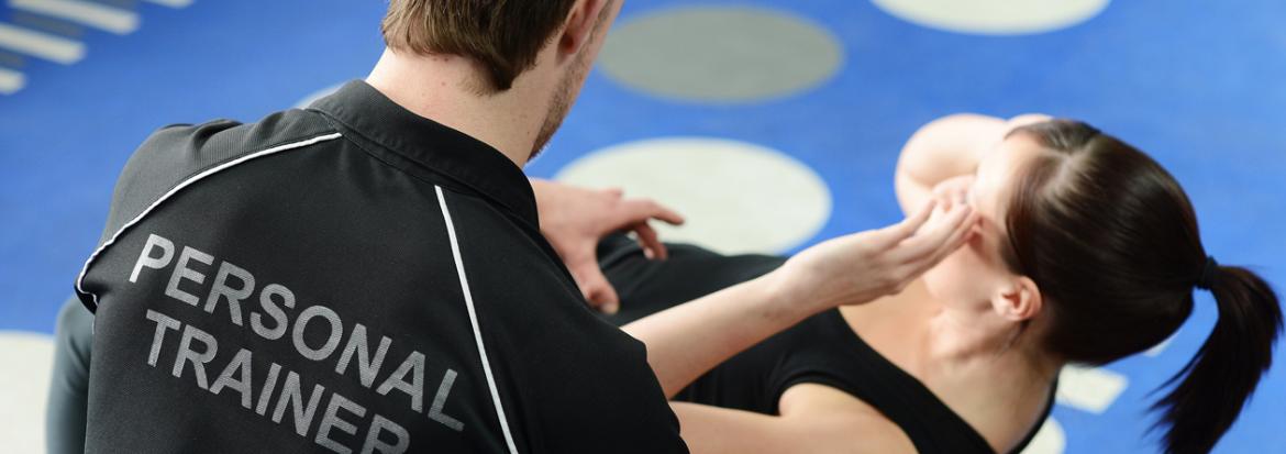 En personlig trener assisterer en person som tar situps. Foto