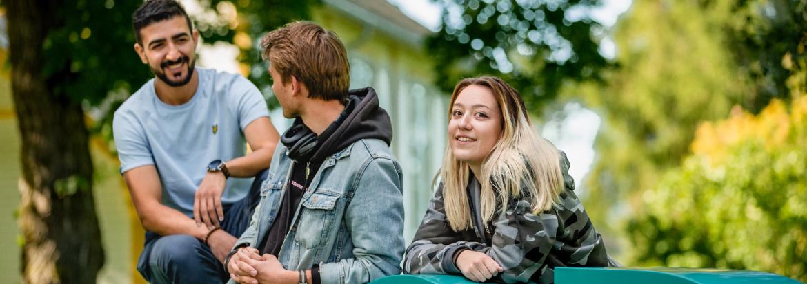 Tre studenter ved Nord-logo.