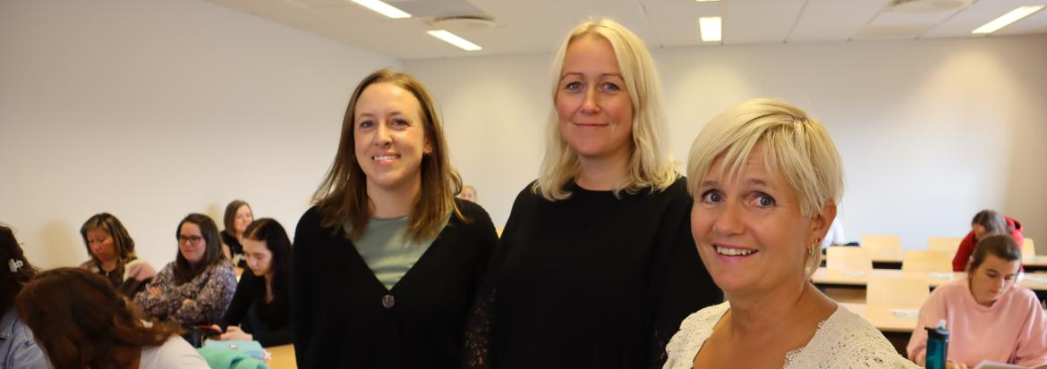 To studenter og leder for barnehagelærerutdanningen smiler