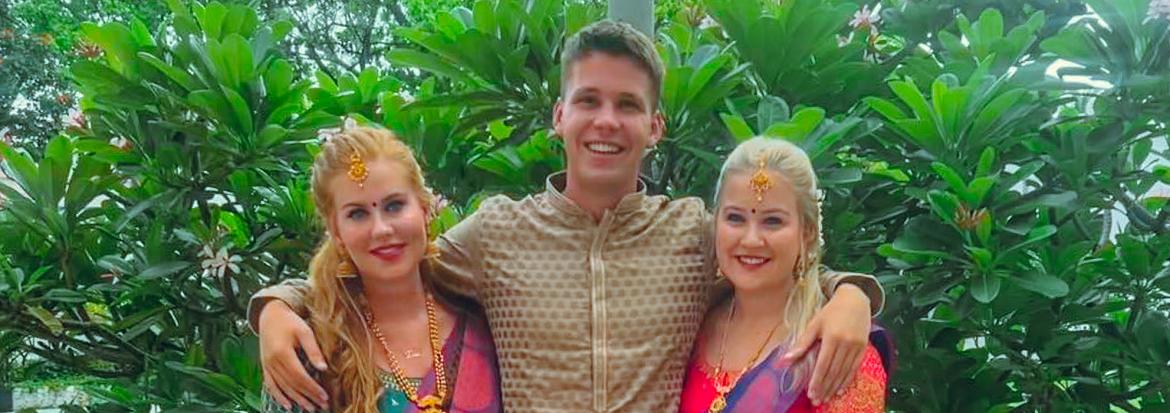 En mann og to kvinner i indisk klesdrakt 