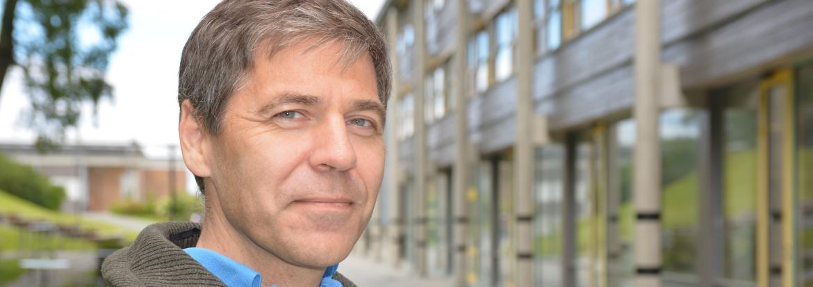 Mann ute foran universitetsbygg