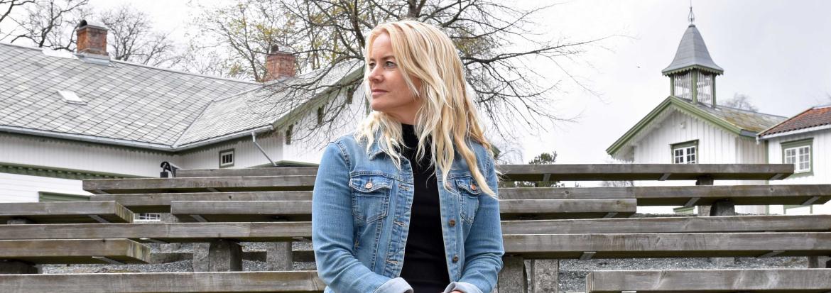 Kvinne som sitter på en benk. Foto