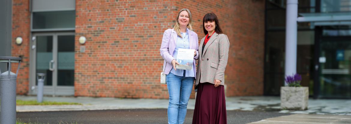 De to forskerne står foran hovedinngangen til Nord universitet.