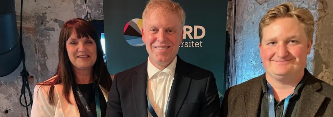 En dame og to menn presenterer boken som de nettopp har gitt ut. Foto.