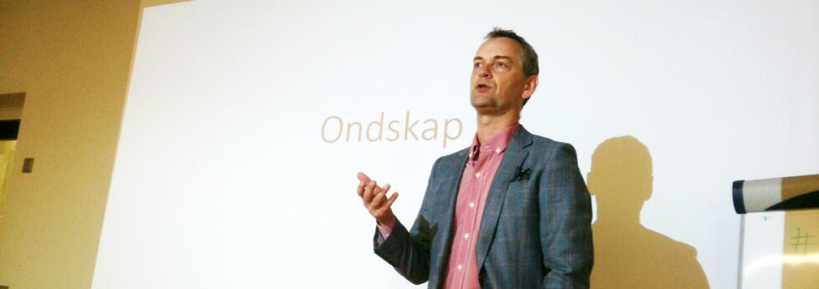 Mann står foran lerret i undervisningssituasjon