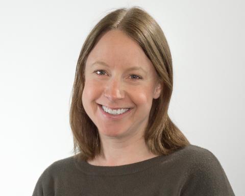 Kvinne med brun genser og brunt hår. Foto.