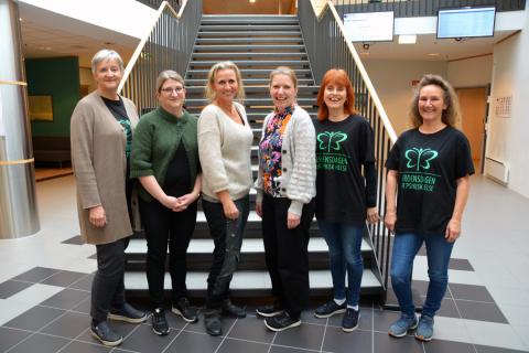 Seks kvinnelige forskere foran trapp.