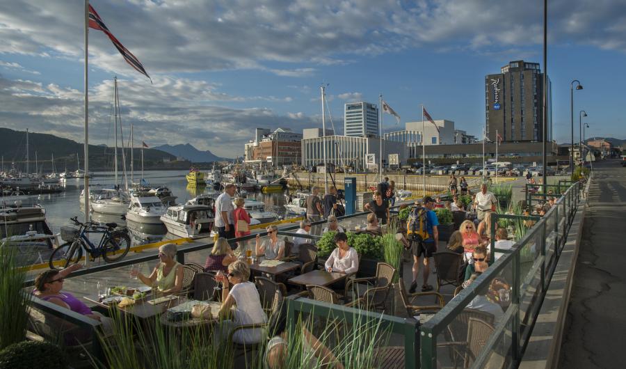 Mennesker som sitter på uteservering i havna i Bodø