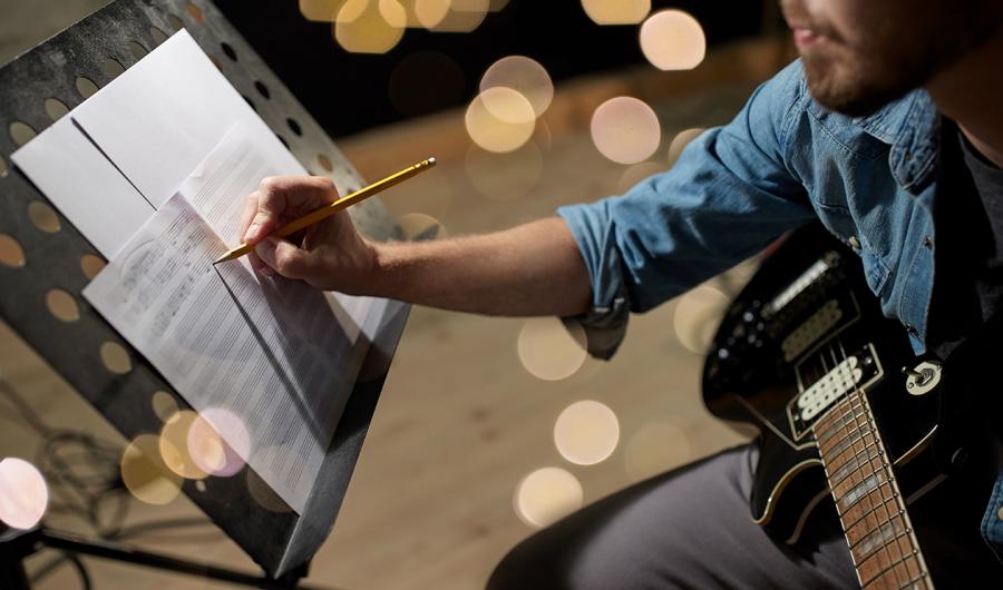 En komponist skriver på et noteark.