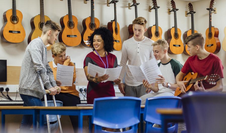 Seks elever i et klasserom for gitarundervisning