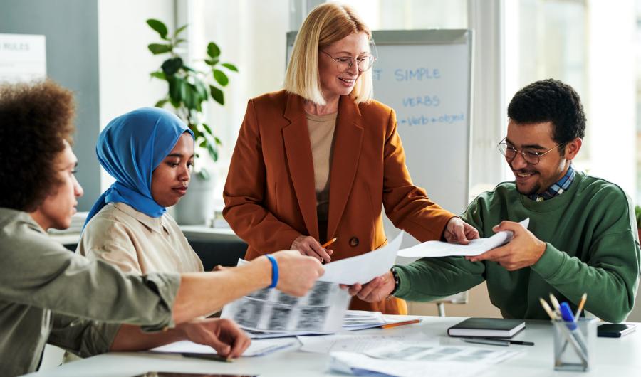 Fire personer arbeider ved et bord.