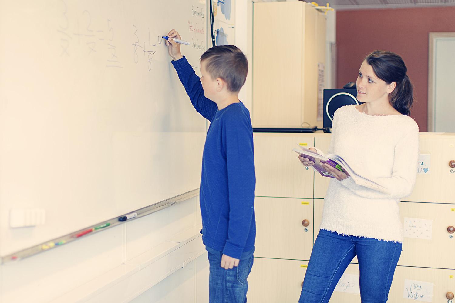 Elev som skriver på tavle.