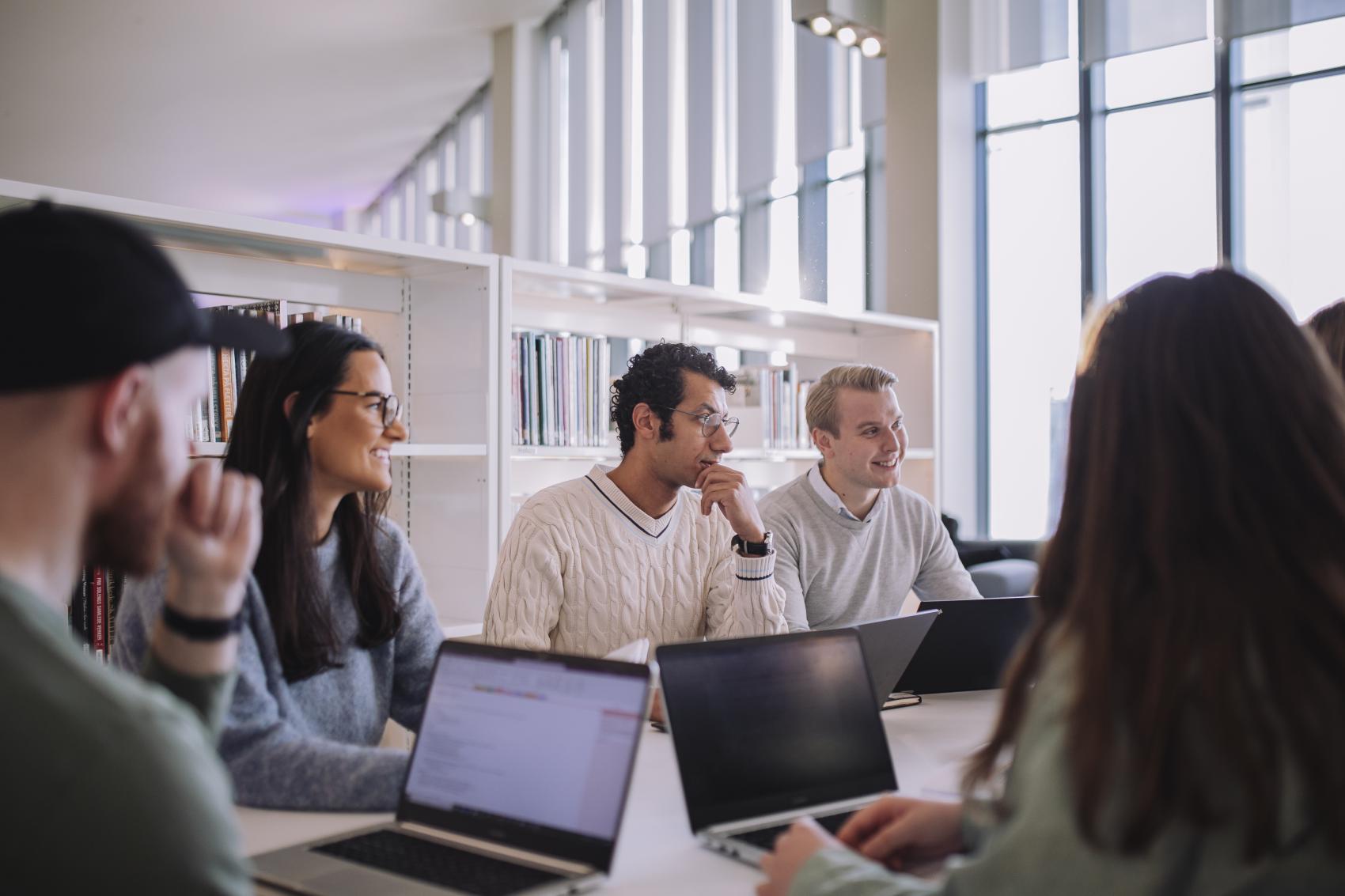 Studenter sitter rundt et bord
