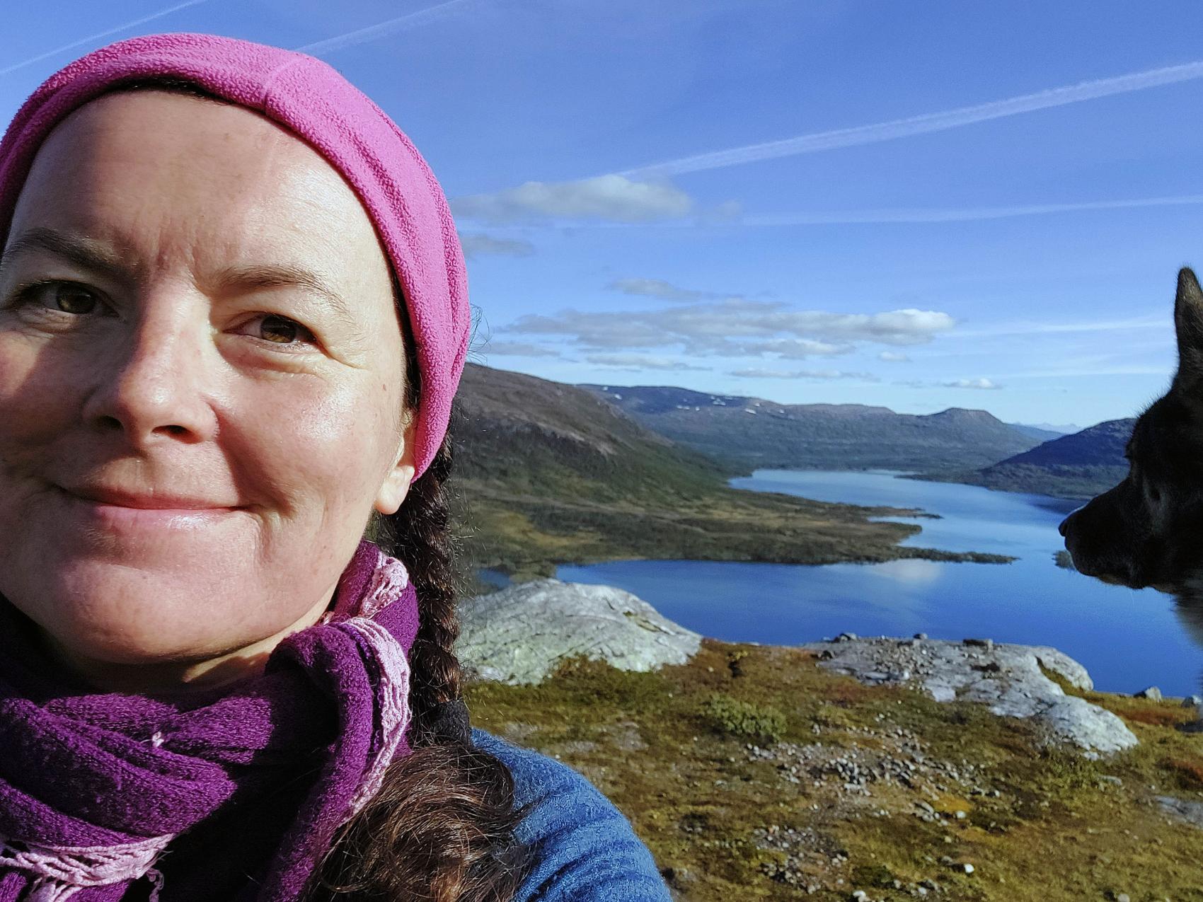 Kvinne på fjelltur med hund.