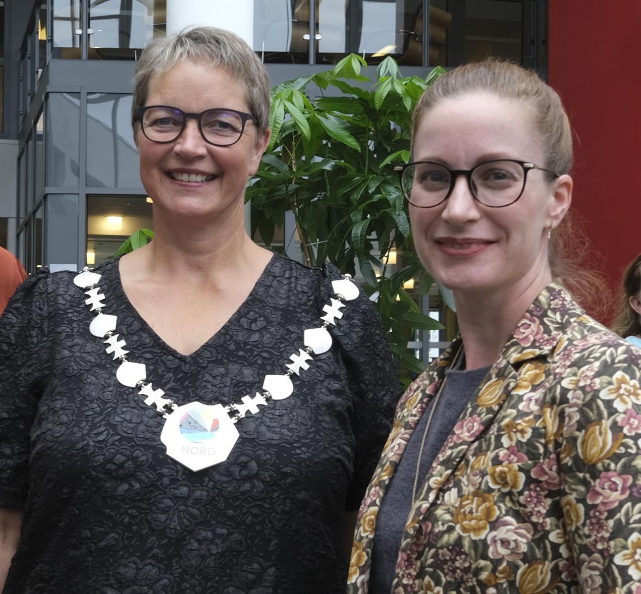 To kvinner som ser i kamera, den ene med rektorkjede. Foto