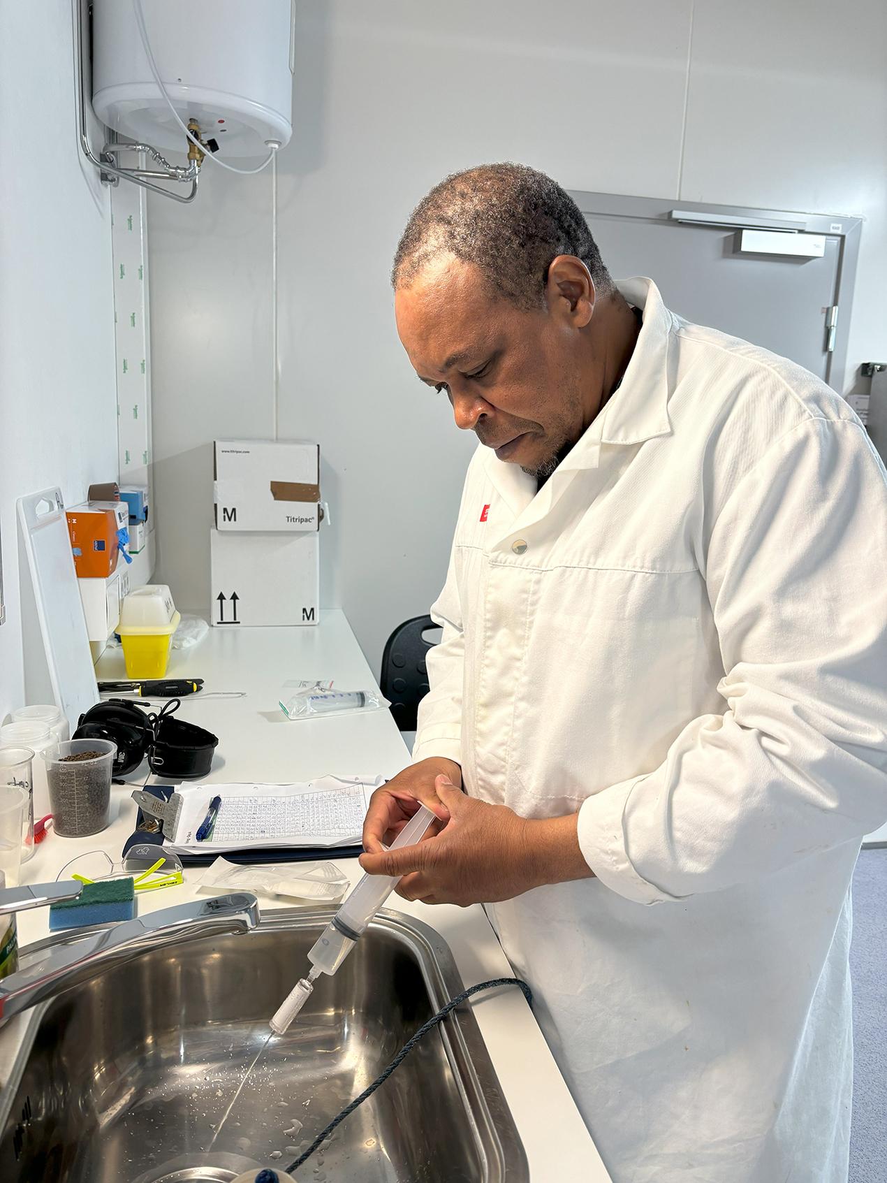 Voksen mann på laboratorium iført hvit frakk. Foto