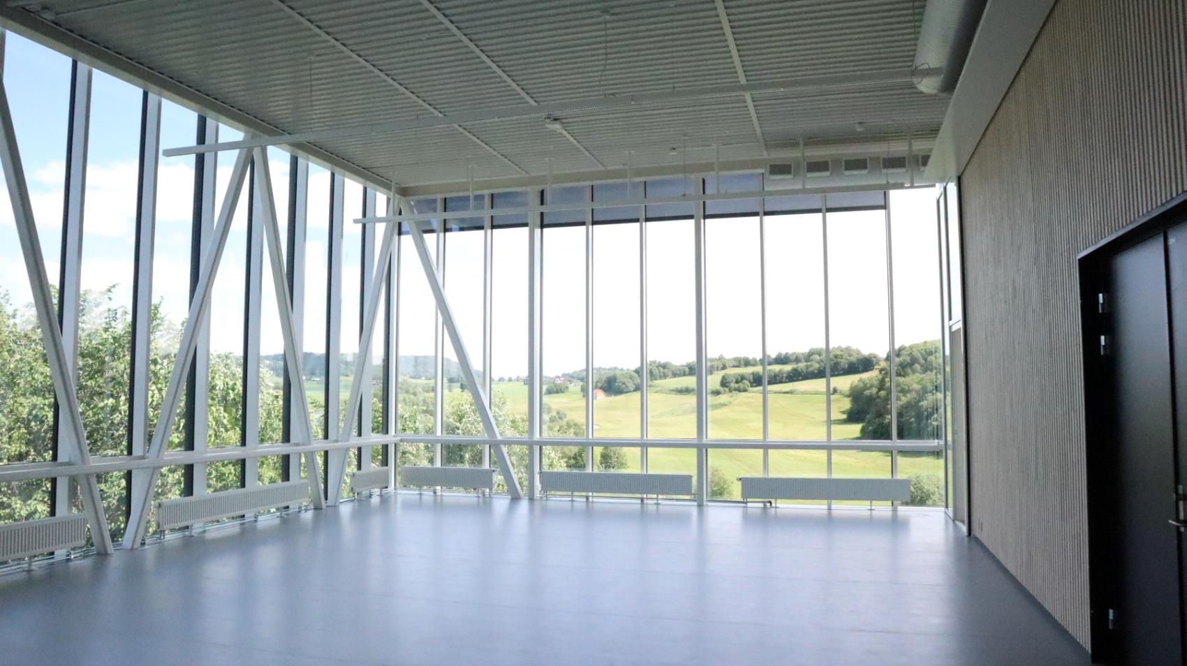 Tom sal med glassfasader, utsikt mot grønne åkre
