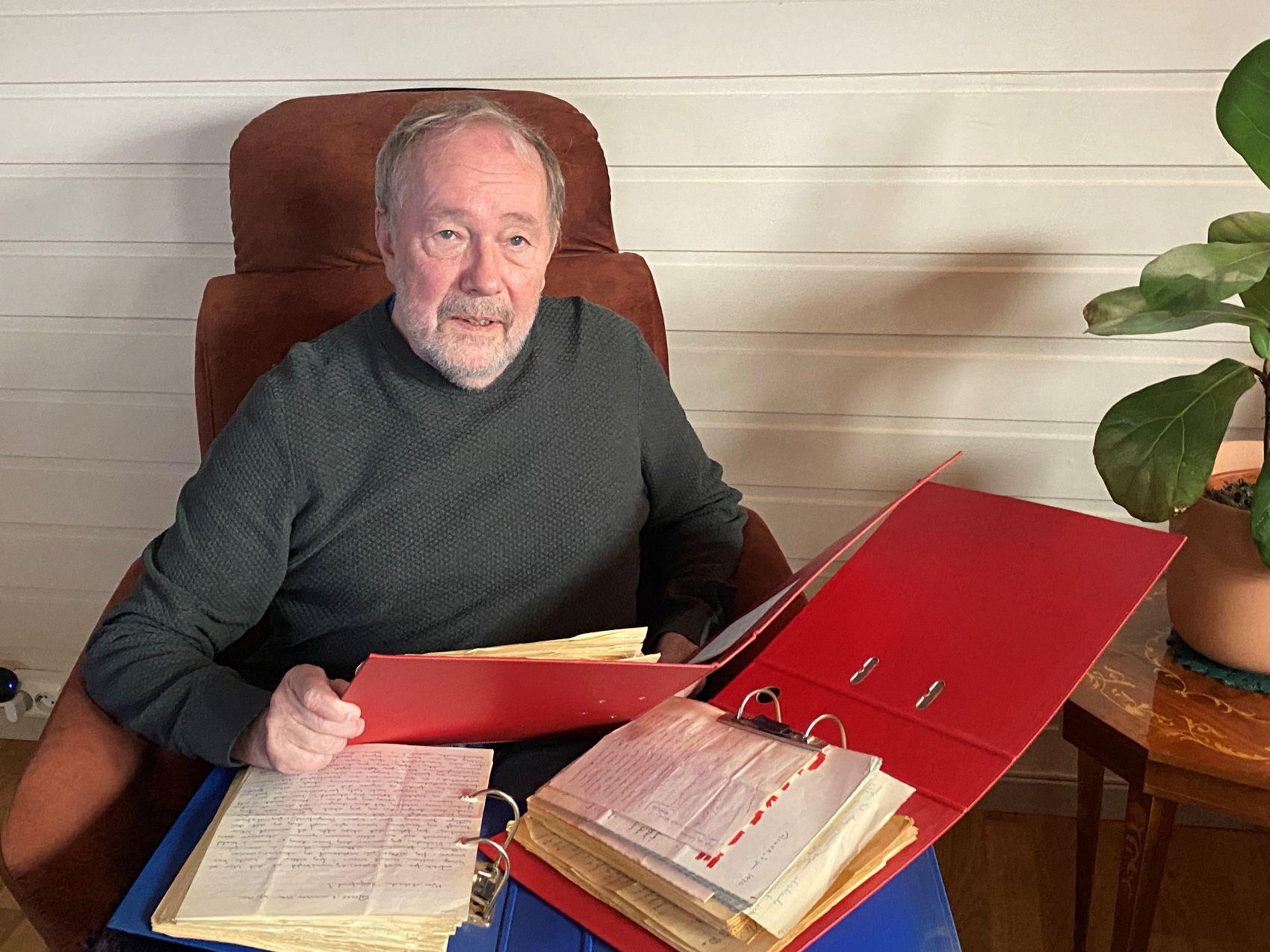 Eldre mann med ringpermer i fanget. Foto