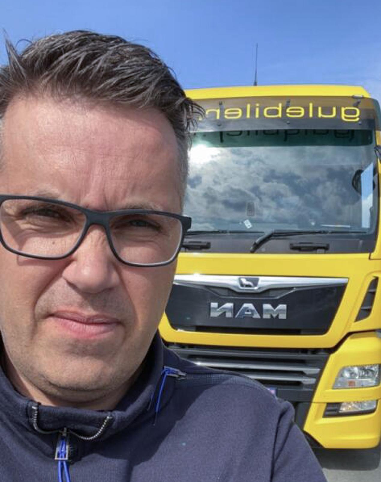 Mann foran lastebil. Foto