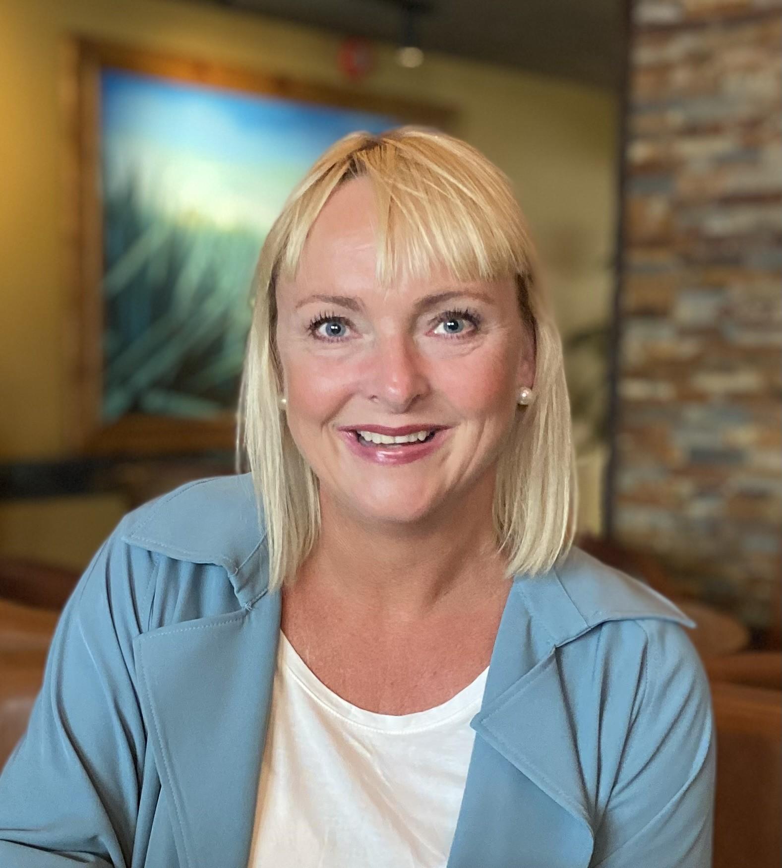 Portrett av smilende dame med lyst halvlangt hår