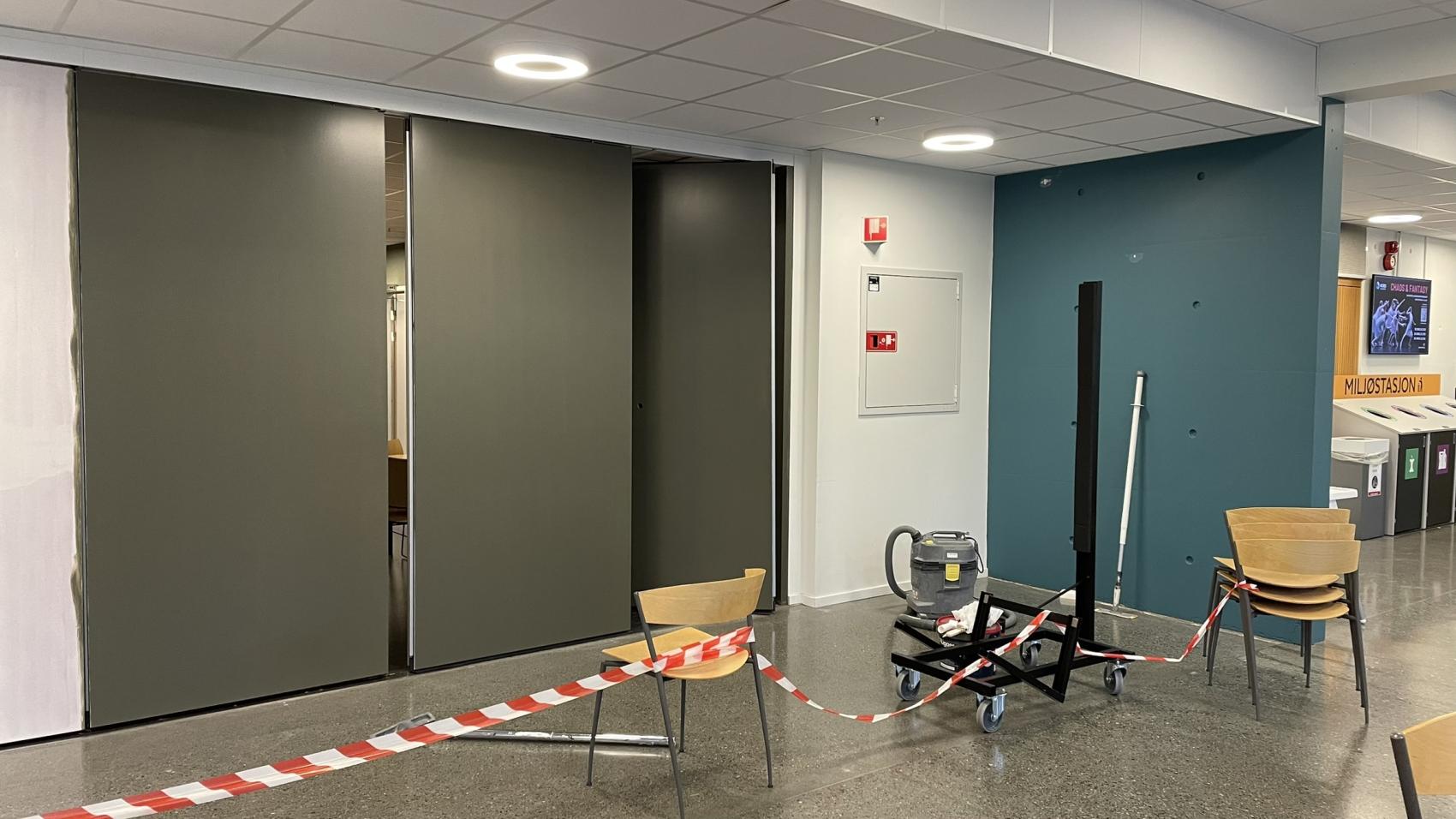 Nymalt men noe uferdig grå vegg med sperrebånd foran