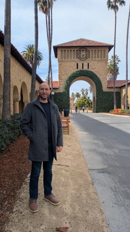 Voksen mann ute foran vakkert bygg