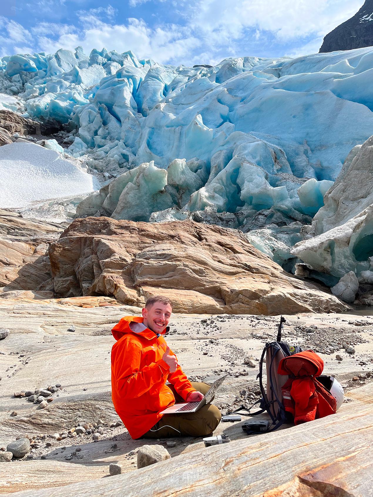 Mannlig forsker foran isbre. Foto