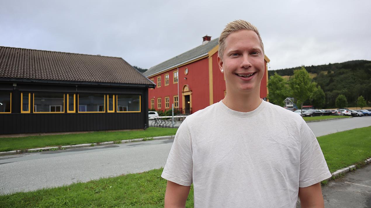 Ung mann i hvit t-skjorte ute. Foto