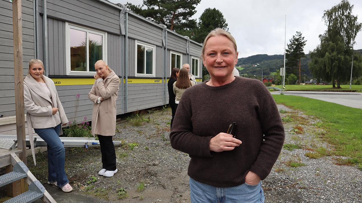 Voksen kvinne ute med unge jenter i bakgrunn. Foto