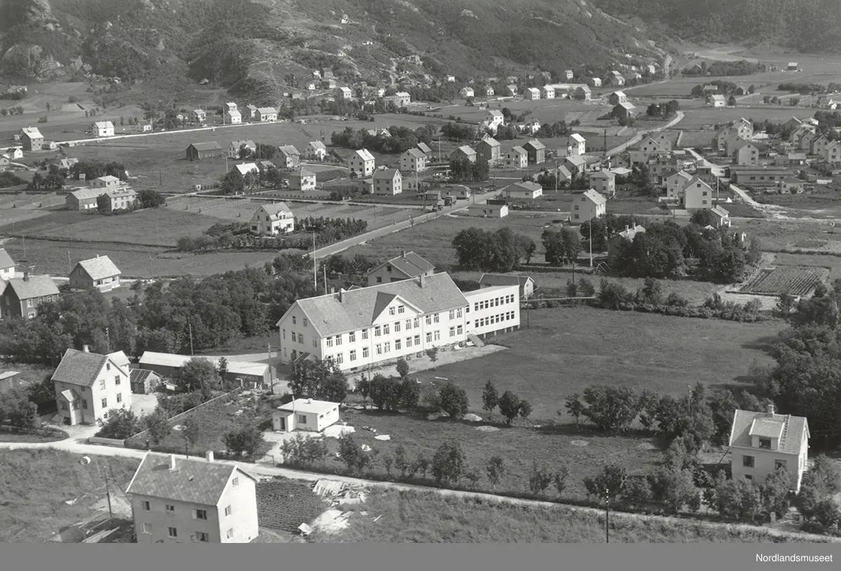 svarthvitt oversiktbilde over boligområde med større bygning i forgrunnen