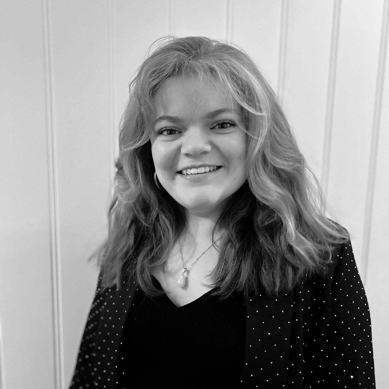 Kvinne med langt hår og sort antrekk. Foto