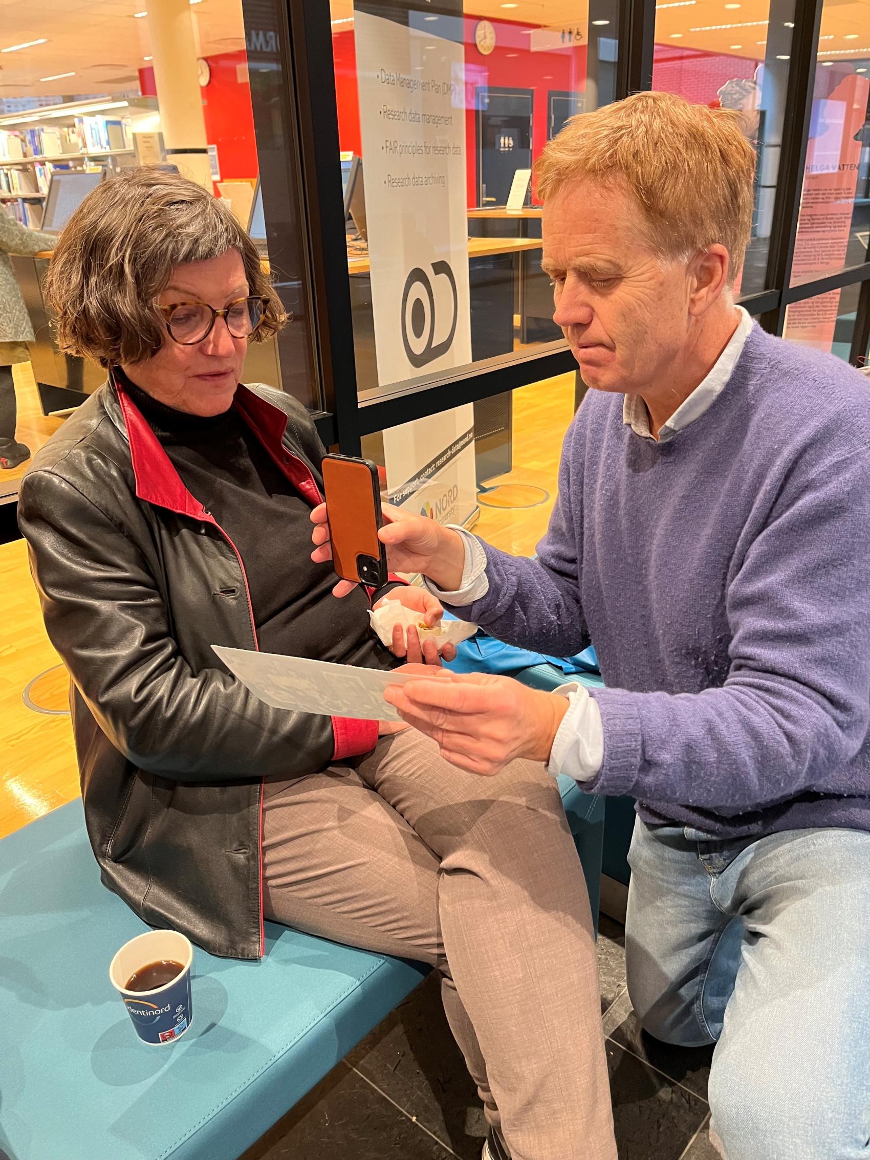 Kvinne og mann som ser på et gammelt bilde sammen. Foto