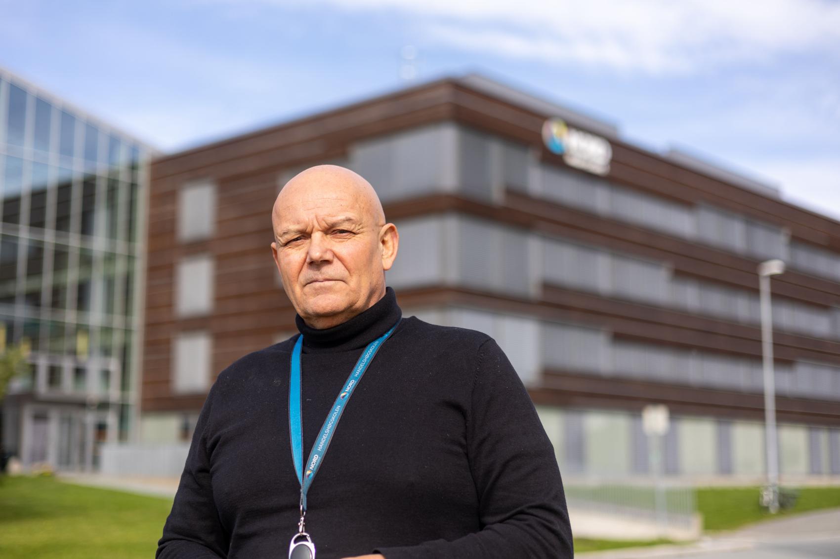 Mannleg forskar ute framfor stor bygning