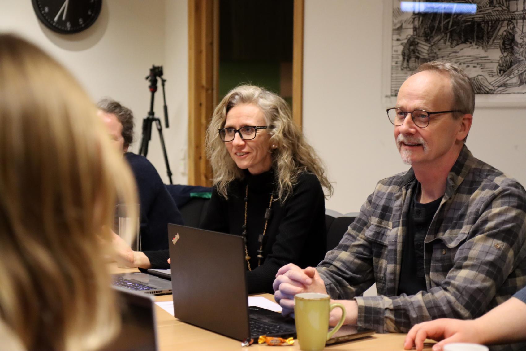 Tre voksne mennesker ved eit bord i eit møte. Foto