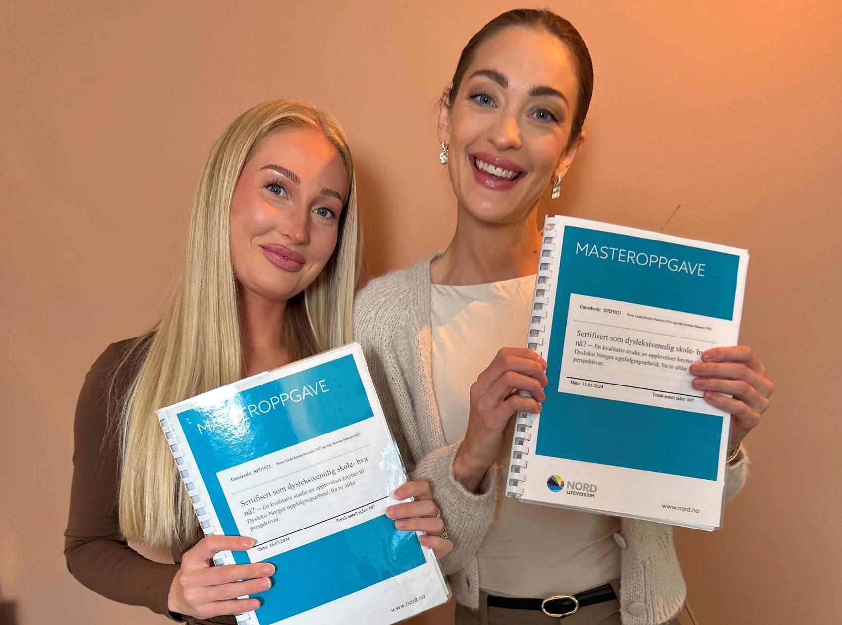 To kvinner med masteroppgåve i hendene. Foto