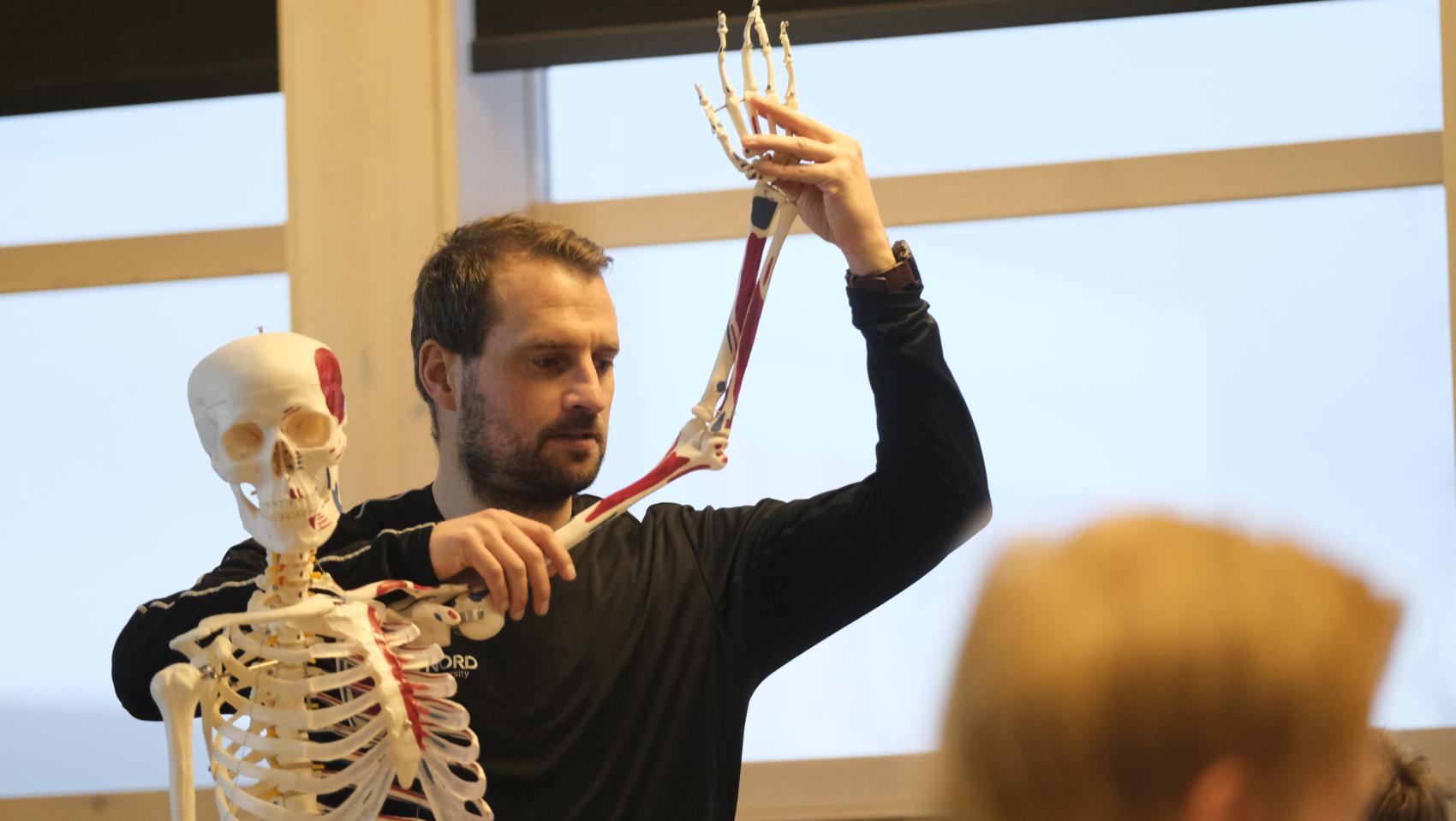 Mann ved skjelett. Foto