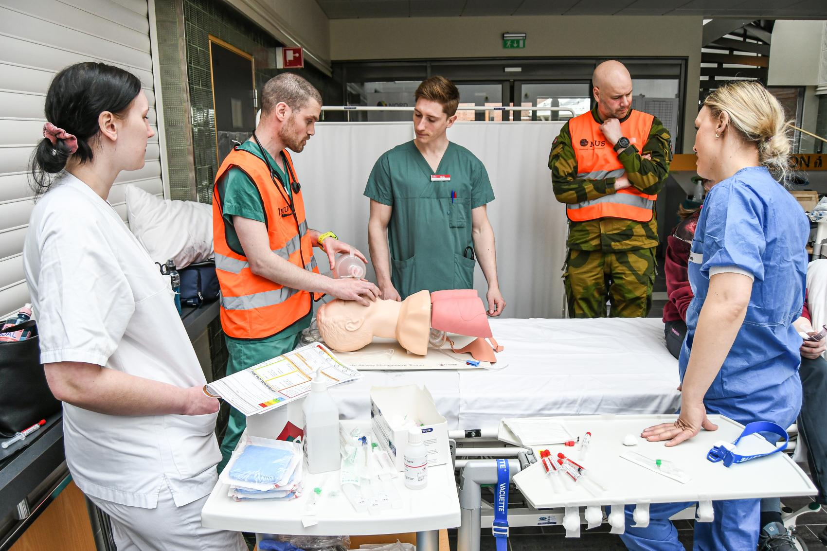 Studenter og lærere under øvelse, ved operasjonsbord. Foto.