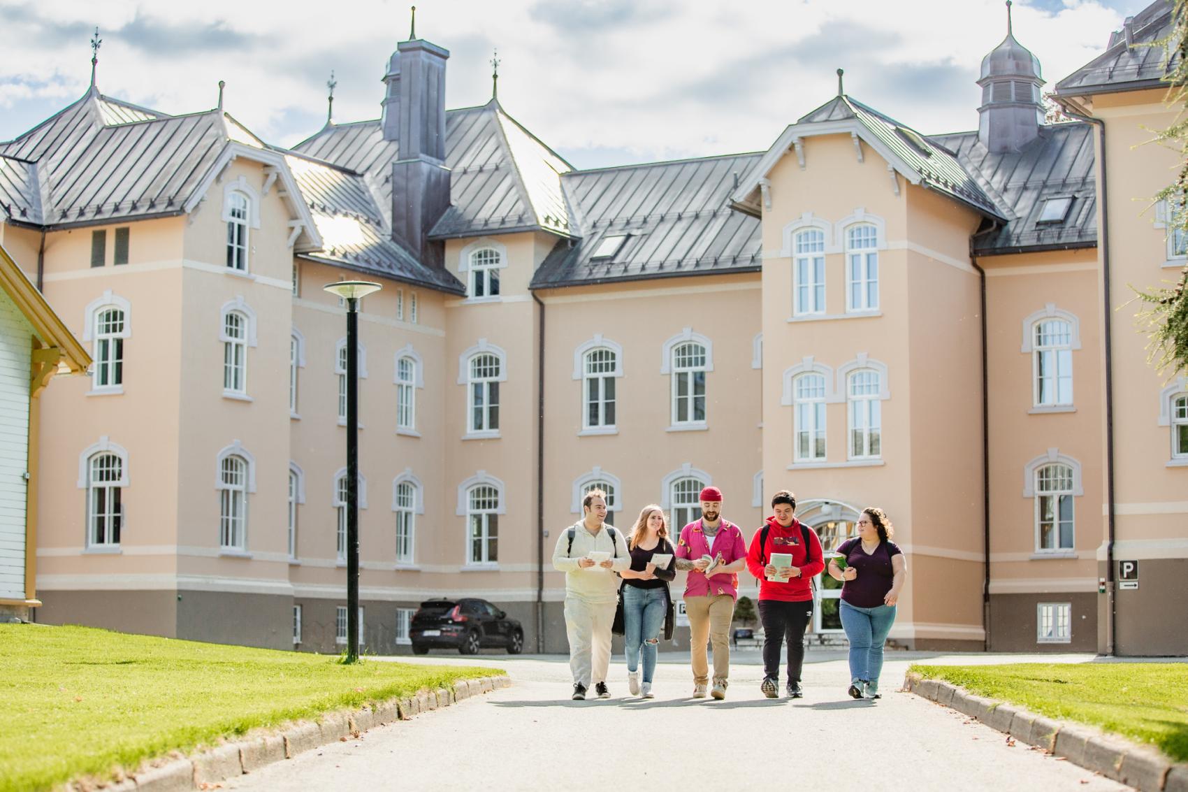 Studenter foran universitetsbygg. Foto.