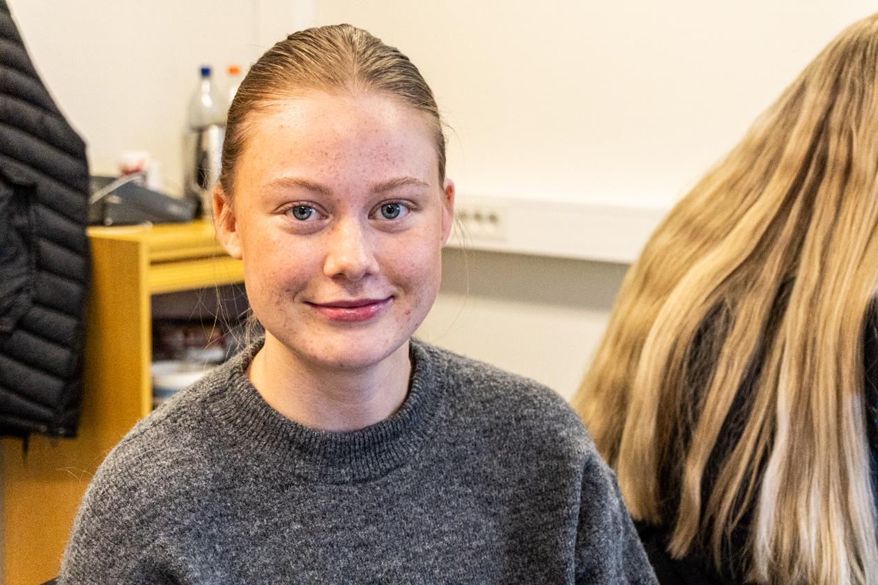 Ung kvinne med langt hår festa i hestehale. Foto